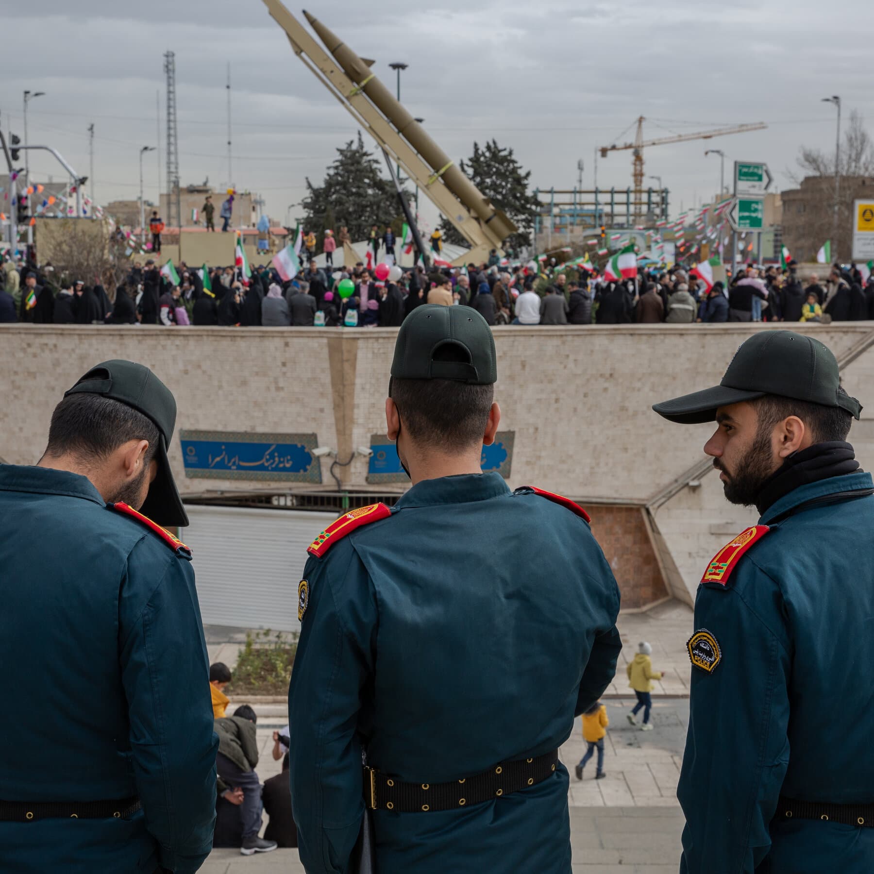 A gritty, high-contrast comic book style illustration of a hand reaching for a red button on a desk, while a reflection in the glossy desk surface shows a chaotic explosion. The colors should be muted grays and stark reds.