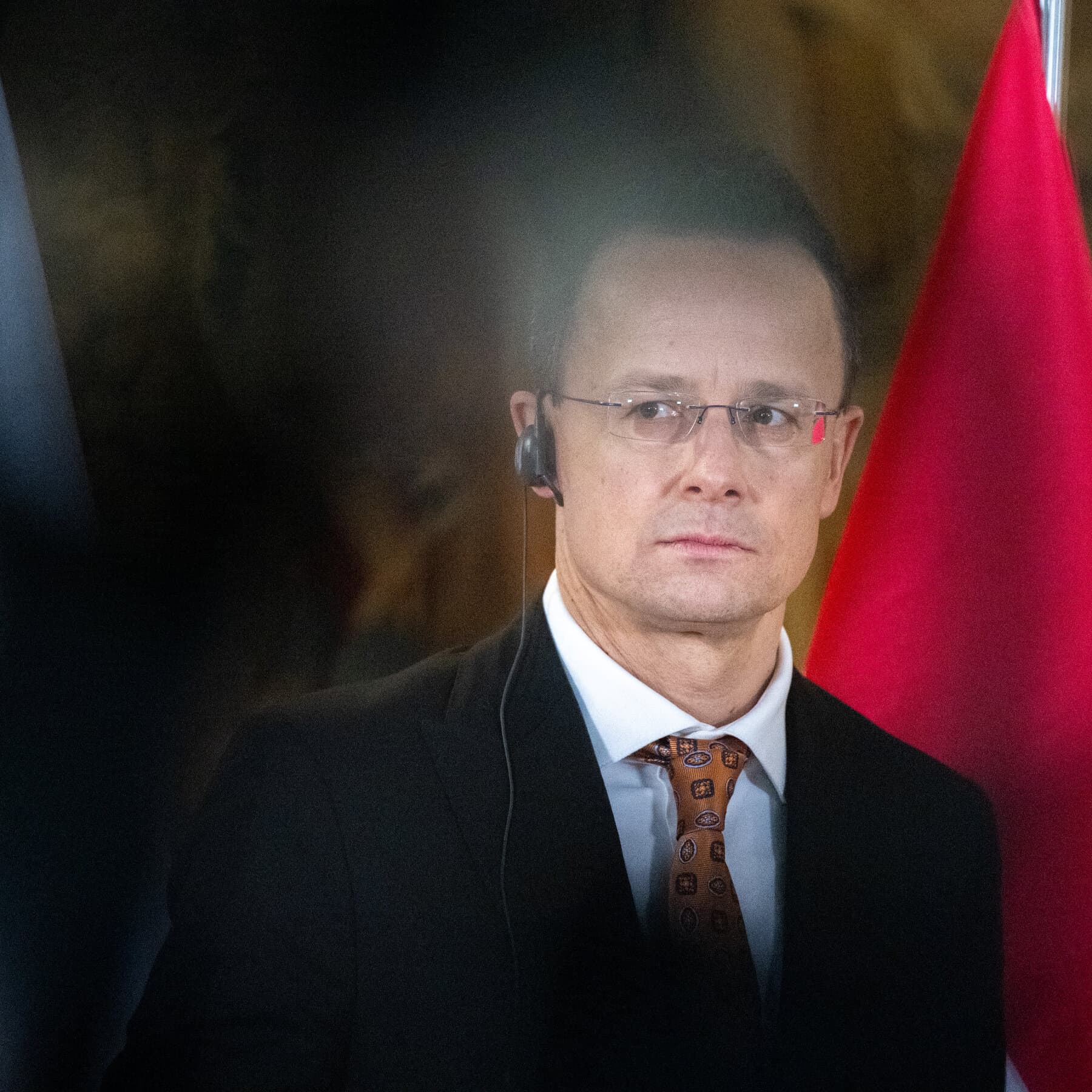 A dimly lit, dusty European bureaucratic meeting room. In the center, a massive pile of euro banknotes is tied down with red tape. A single, bored-looking man in a suit sits with his feet up on the money, blocking the door. Abstract, moody, cynical oil painting style.