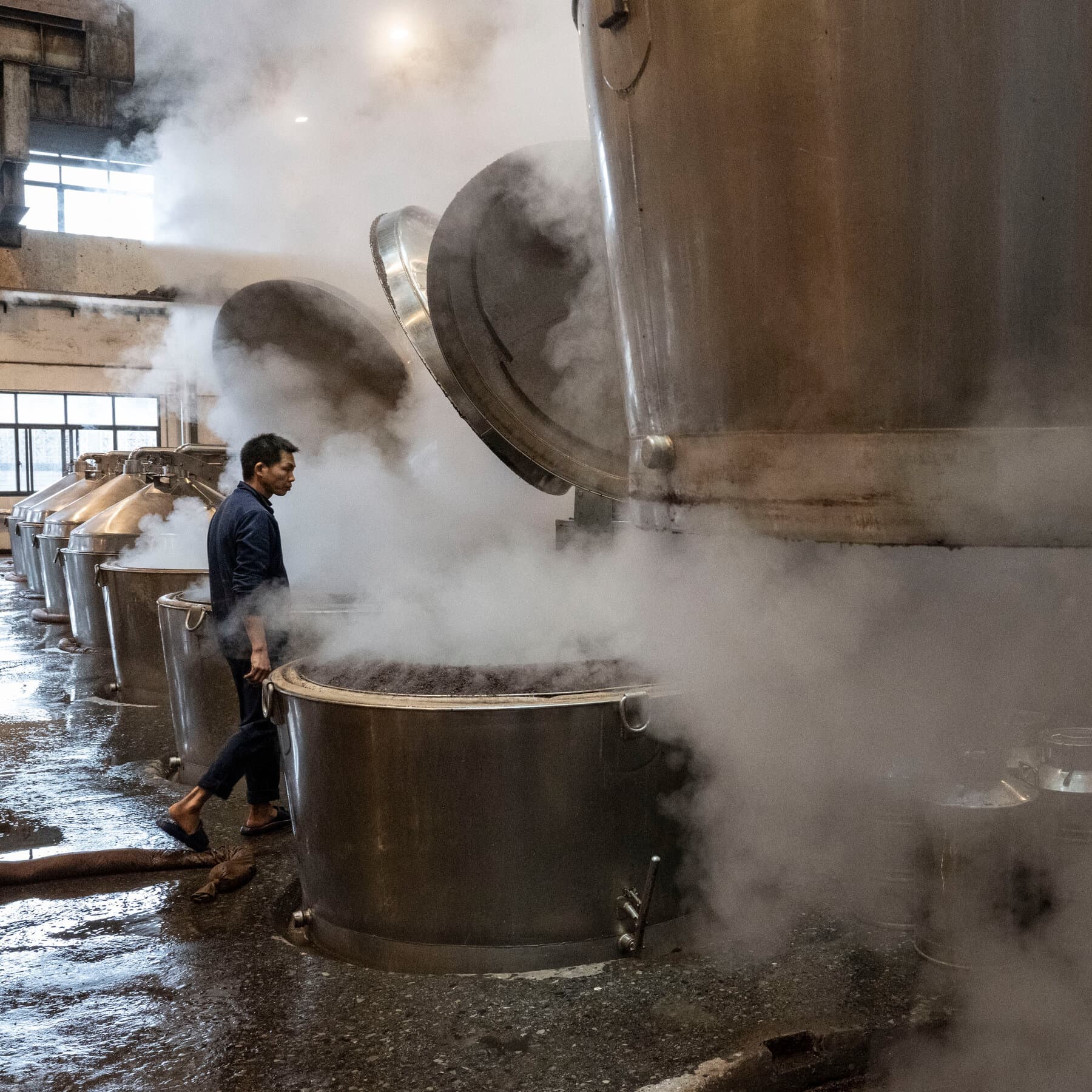 A moody, realistic photo of a luxurious Chinese banquet table left abandoned. Half-empty bottles of white liquor, overturned chairs, leftover food, and a gloomy, desaturated atmosphere. No people.