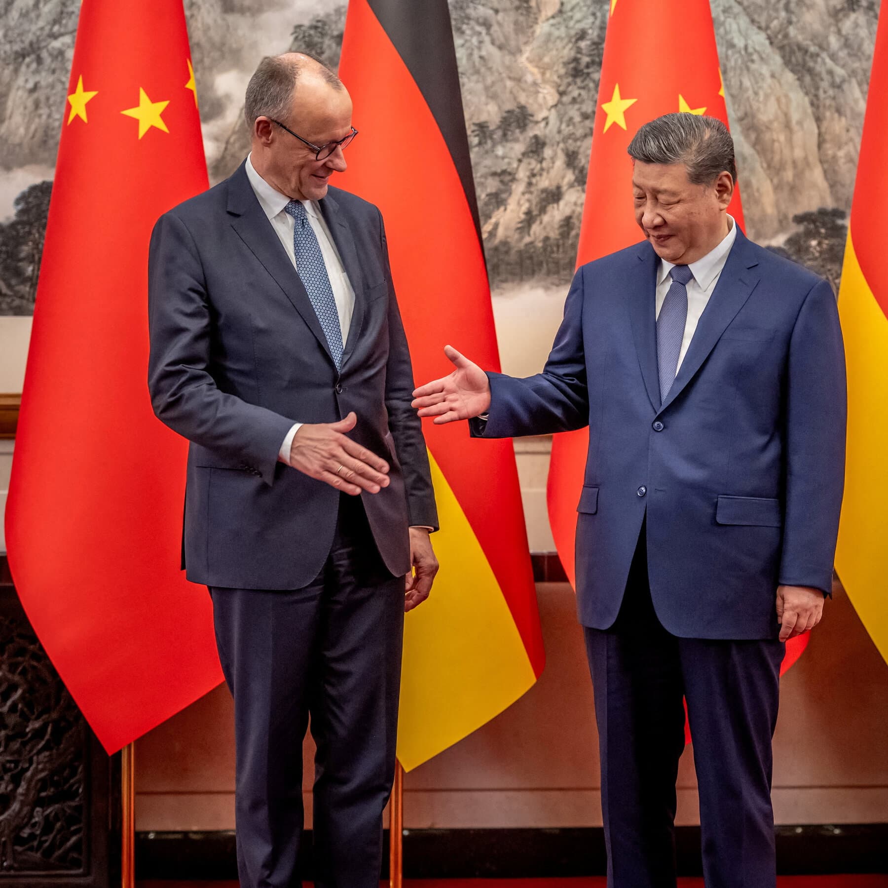 A hyper-realistic editorial illustration showing a small, stern man in a grey German business suit standing on a tiny wooden soapbox, pointing an accusing finger at a gigantic, calm, red dragon. The dragon is resting on a pile of shipping containers and gold coins, looking down at the man with a mix of boredom and amusement. The background is a smoggy, industrial skyline of Beijing mixed with crumbling European architecture. The lighting is dramatic and moody, emphasizing the size difference.