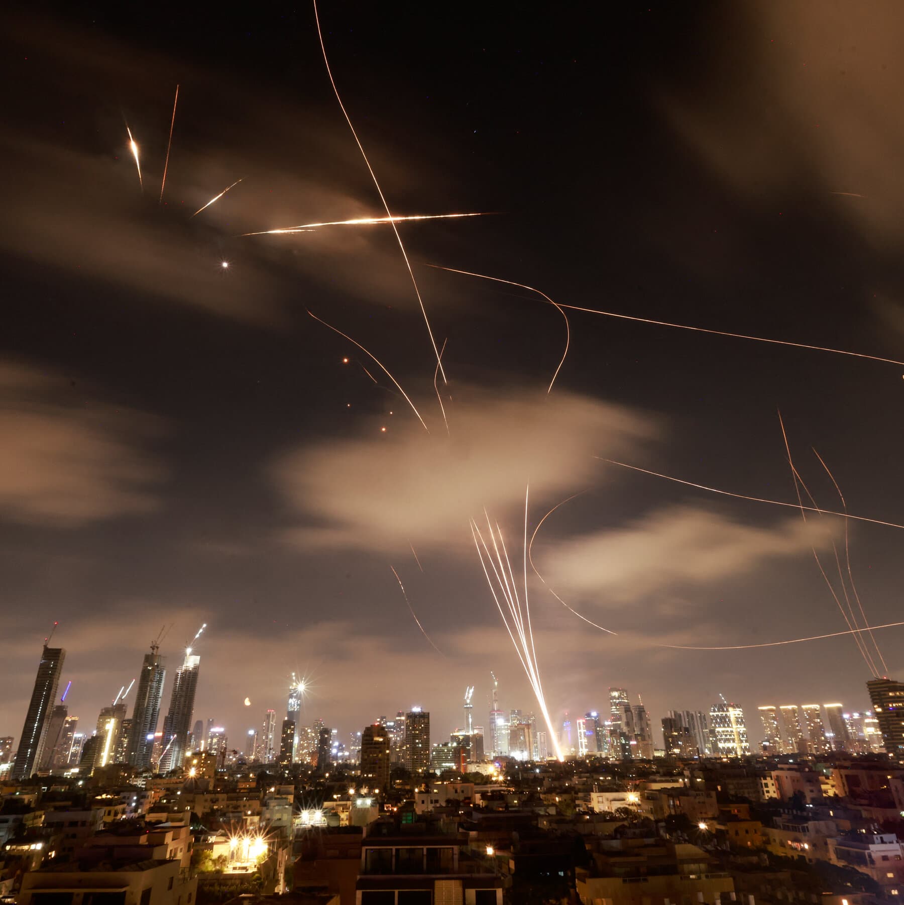 A hyper-realistic, cynical editorial illustration showing a massive, high-tech missile shield generator that is unplugged and covered in cobwebs. Beside it, a politician in a suit is frantically trying to defend himself with a tiny wooden umbrella. The background is a dark, stormy geopolitical map.
