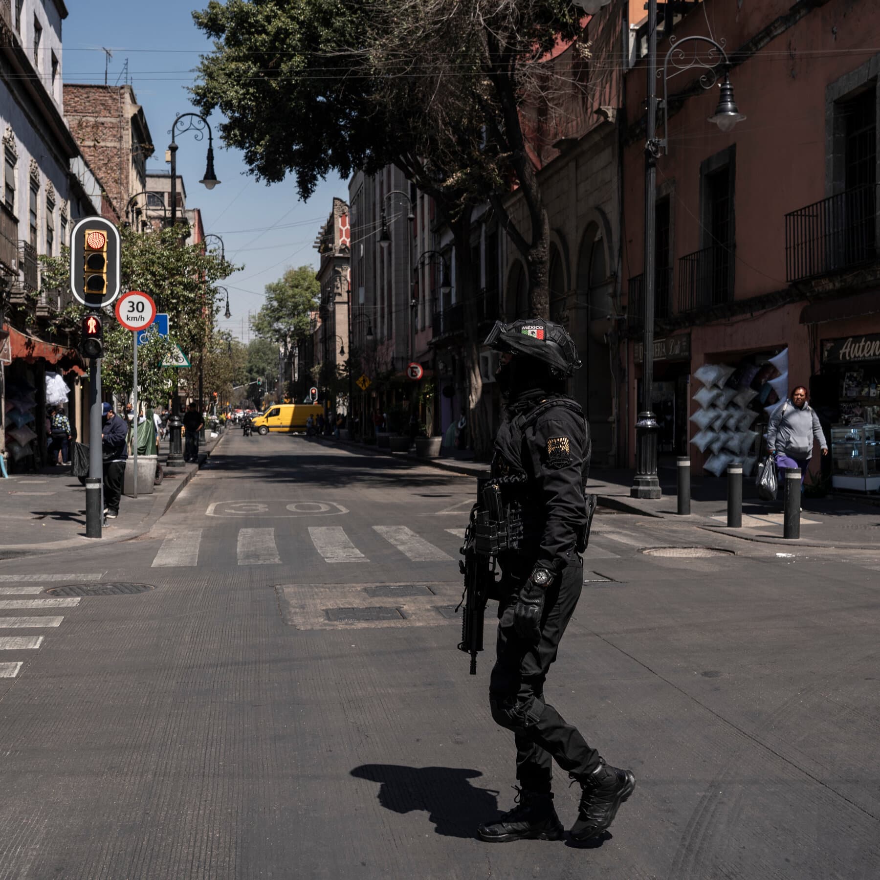 A deflated soccer ball sitting in a puddle of dirty water on a cracked concrete street. In the background, out of focus, is yellow police tape and the flashing red and blue lights of a police car. The lighting is dim and gritty, like a cloudy evening. Realistic style.