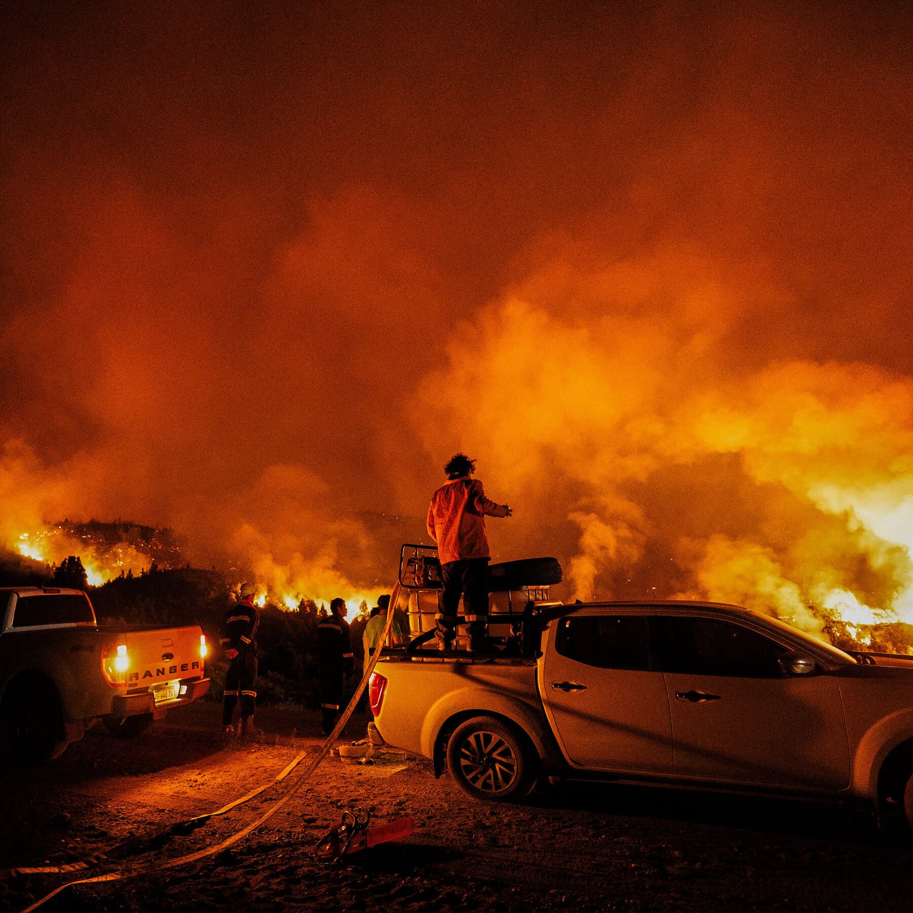 A conceptual illustration of a globe where multiple continents are smoldering with smoke simultaneously. In the foreground, a single, small, battered toy fire truck sits alone on a desk with a 'Out of Service' sign hanging on it. The lighting is dim and moody, evoking a sense of abandonment and cynicism.