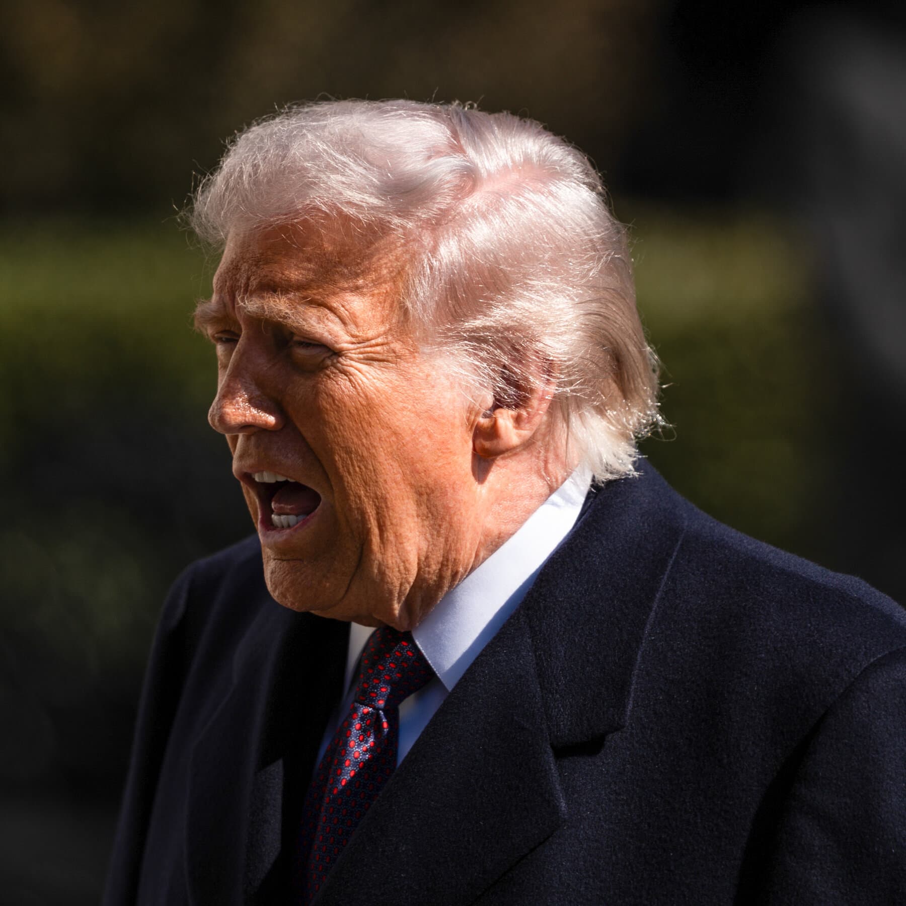 A close-up, high-contrast photo of a single sheet of paper resting on a polished mahogany desk in a dimly lit office. The text on the paper is heavily redacted with black bars, leaving only the words 'MALIGN ACTIVITIES' visible. In the blurred background, two men in dark suits are shaking hands, ignoring the document. The lighting is cold and cynical, emphasizing the emptiness of the page.