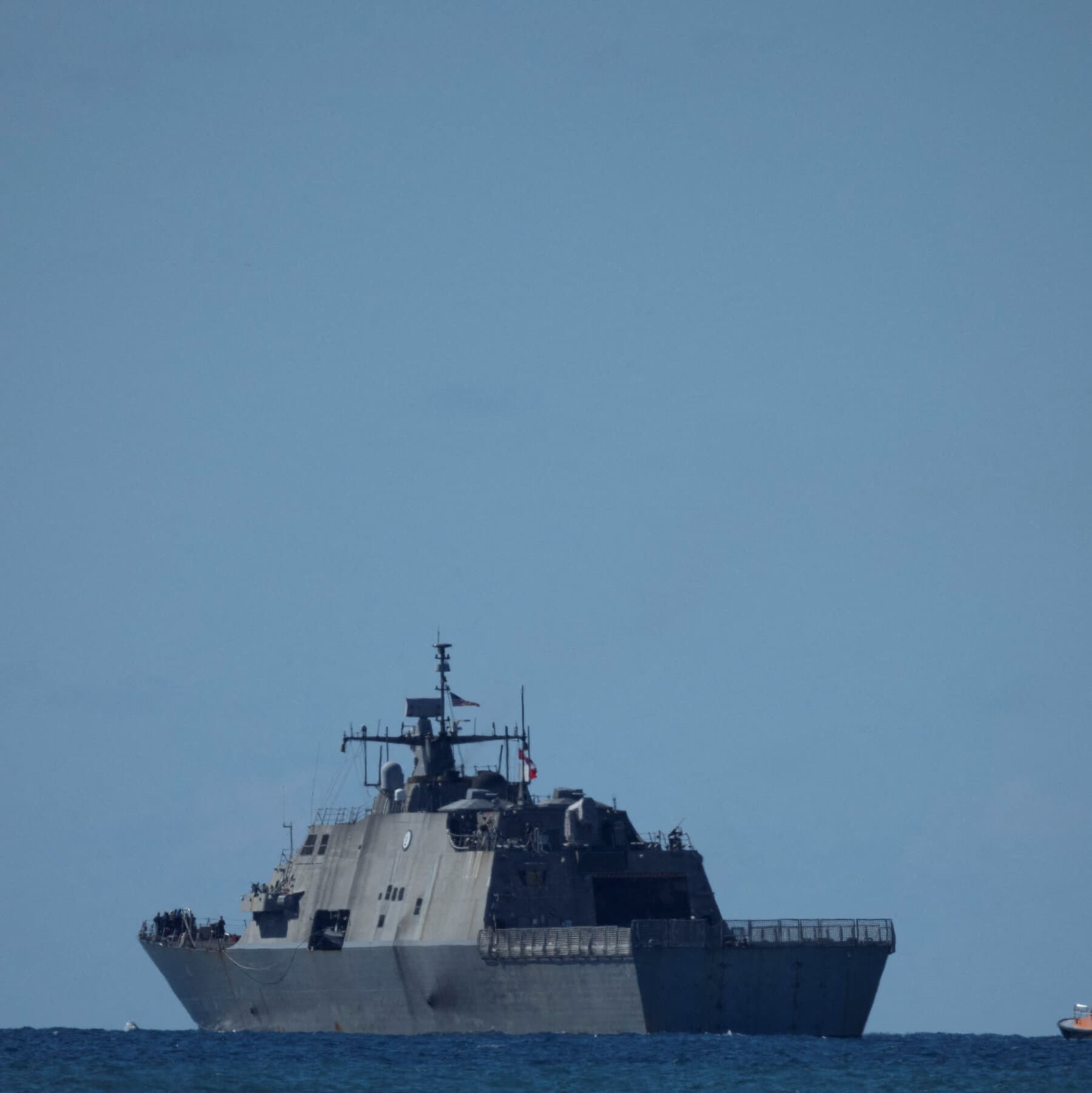 A hyper-realistic, gloomy image of a massive, modern US Navy destroyer sailing slowly next to a rusty, industrial oil tanker in choppy, dark green waters. The sky is grey and overcast. The perspective is from a low angle, making the ships look imposing and cold.