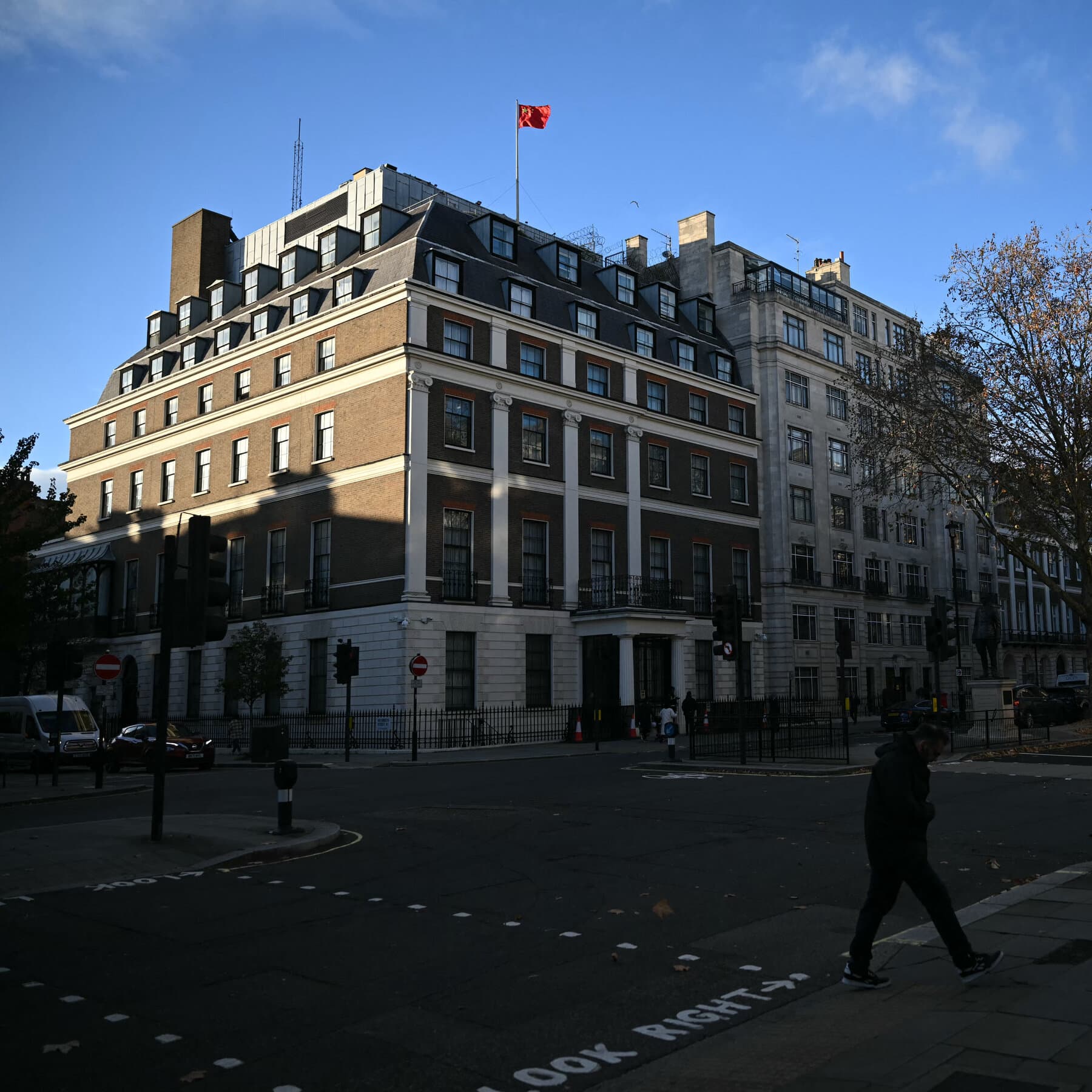 A moody, noir-style illustration of the Palace of Westminster in London under heavy rain, viewed through a wet windowpane. In the foreground, a blurred silhouette of a person in a trench coat holds a red string that is unraveling. The atmosphere is grey, cynical, and bureaucratic. No text.