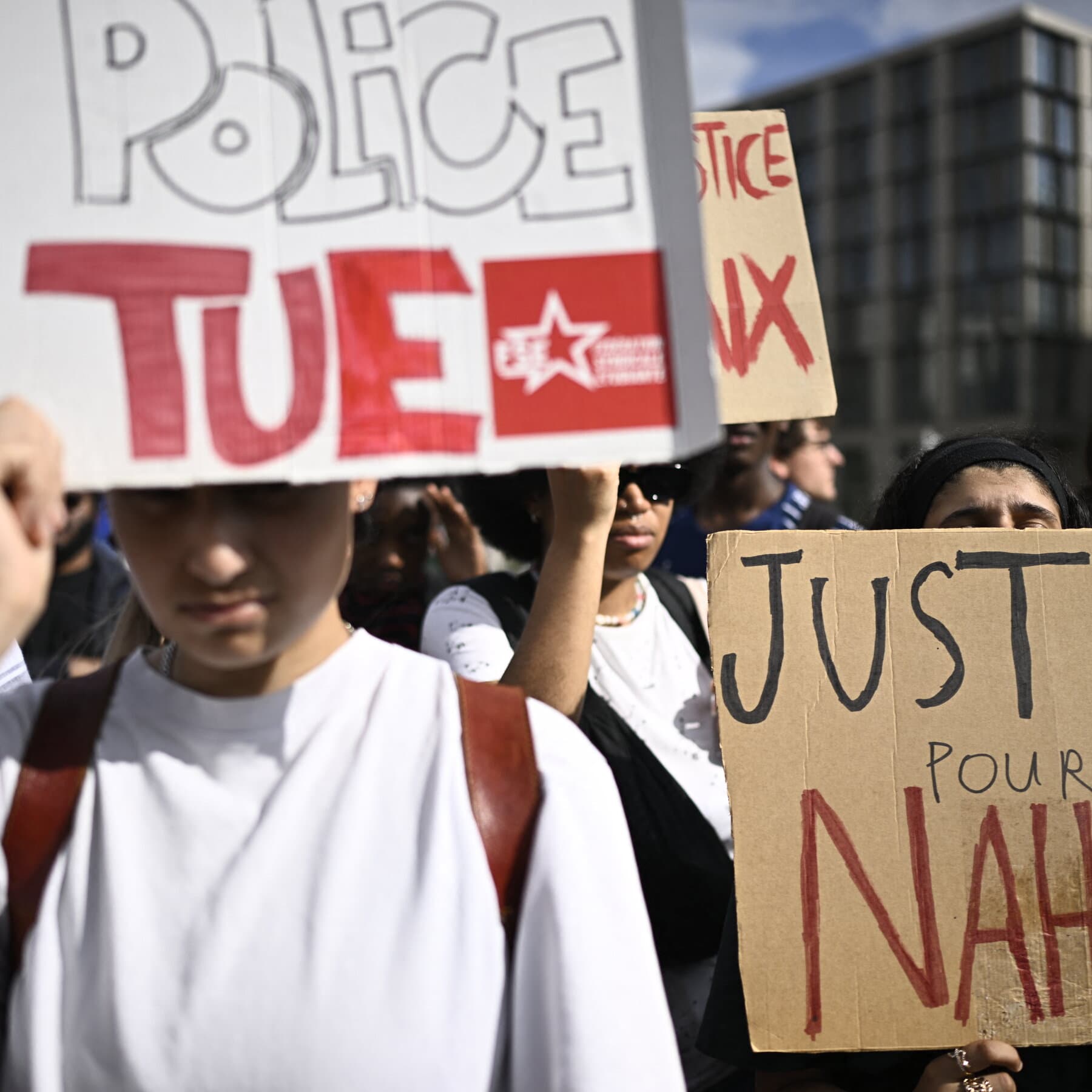 A gritty, dark street in France at night, rain on the pavement reflecting blue police lights, cold atmosphere, no people visible, photorealistic style.