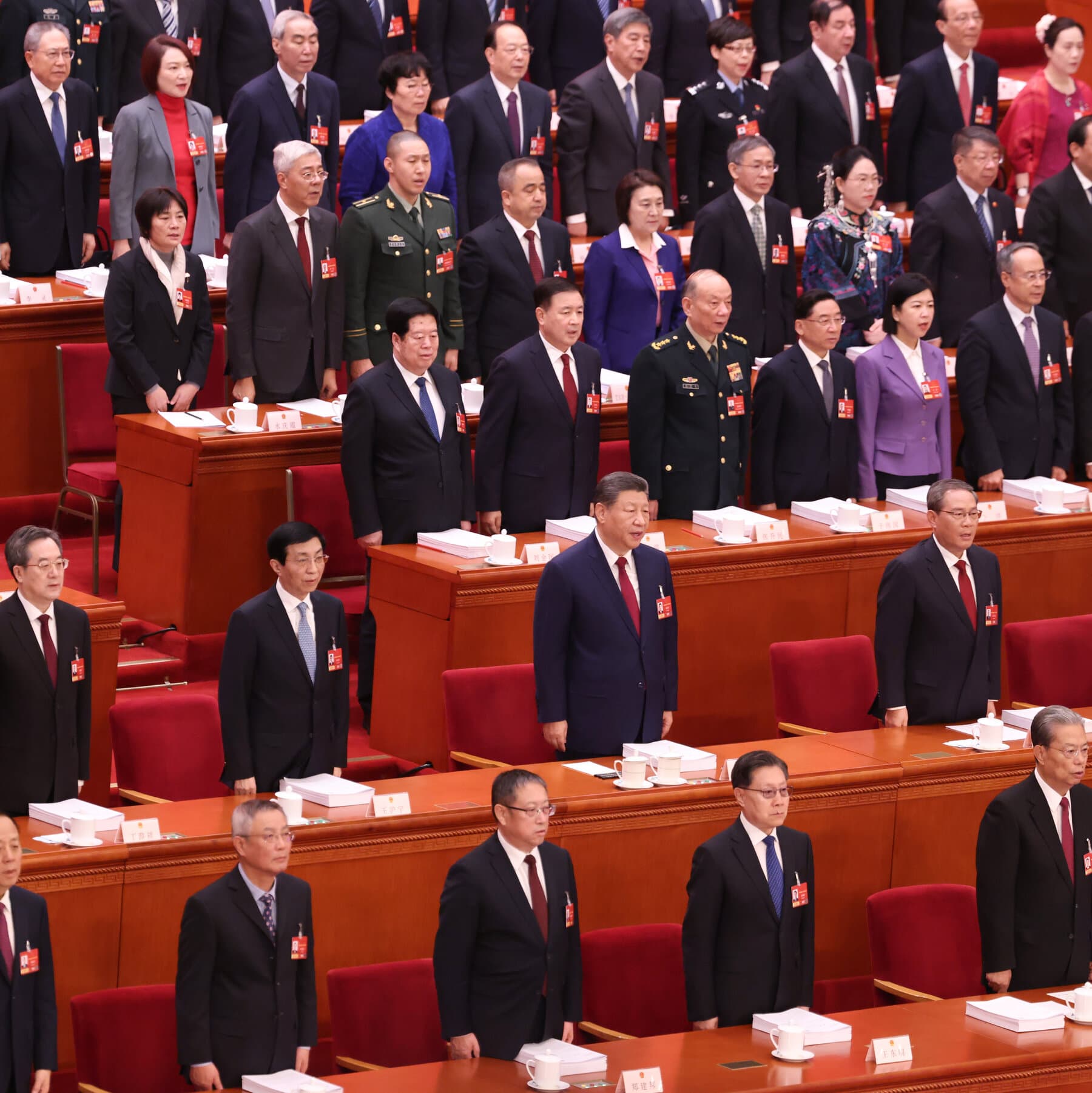 A gritty, cynical editorial illustration showing two giant, rusty robotic hands arm-wrestling over a pile of broken computer chips and toy soldiers. The background is a smoggy, grey industrial sky. One hand has a faint red star, the other a faint star pattern, but both look old and greasy. Dark, moody, comic book style.