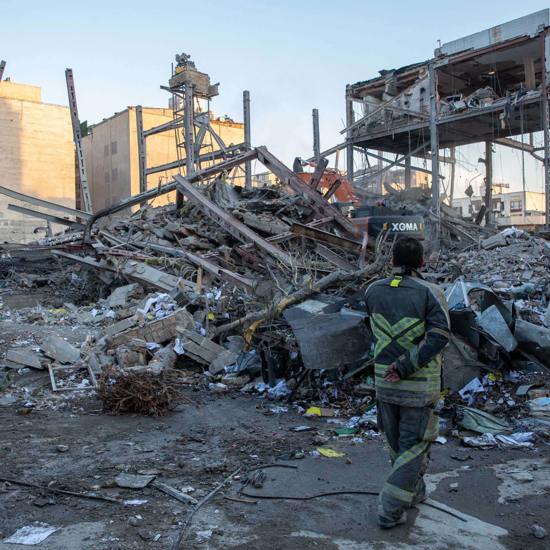 A surreal, gloomy illustration of a single ornate chair sitting alone in the center of a vast, empty stage. In the dark background, faint outlines of other chairs are turned away or toppled over. The lighting is cold and harsh, highlighting the isolation. No text.