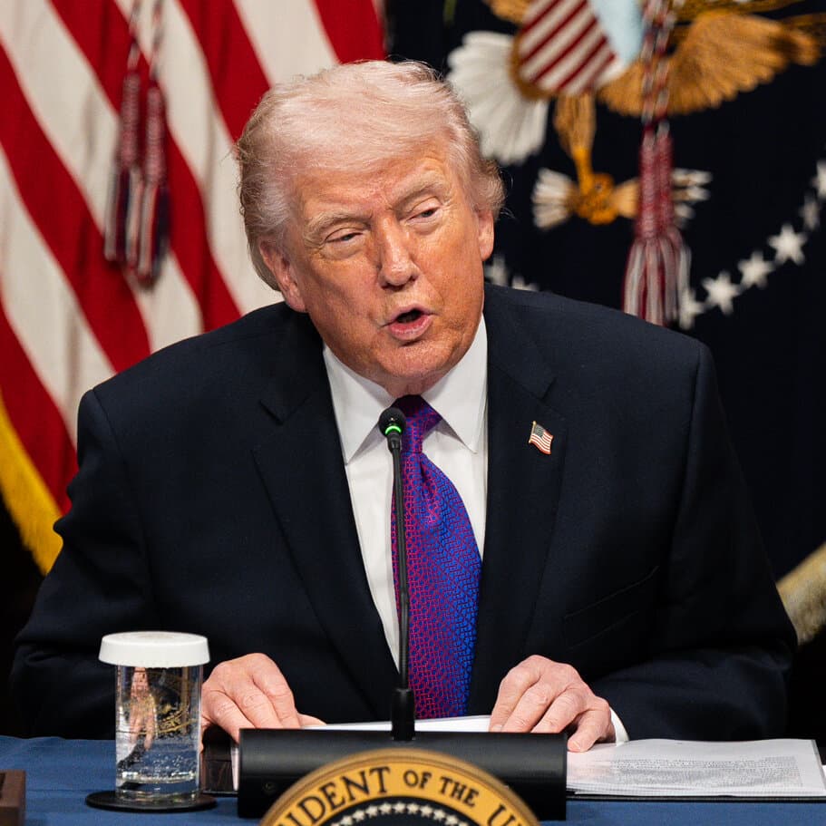 A caricature of Donald Trump wearing a construction hat, holding a blueprint labeled 'Iran' upside down, standing in the middle of a desert ruin, looking confident while pointing a finger at a confused camel.