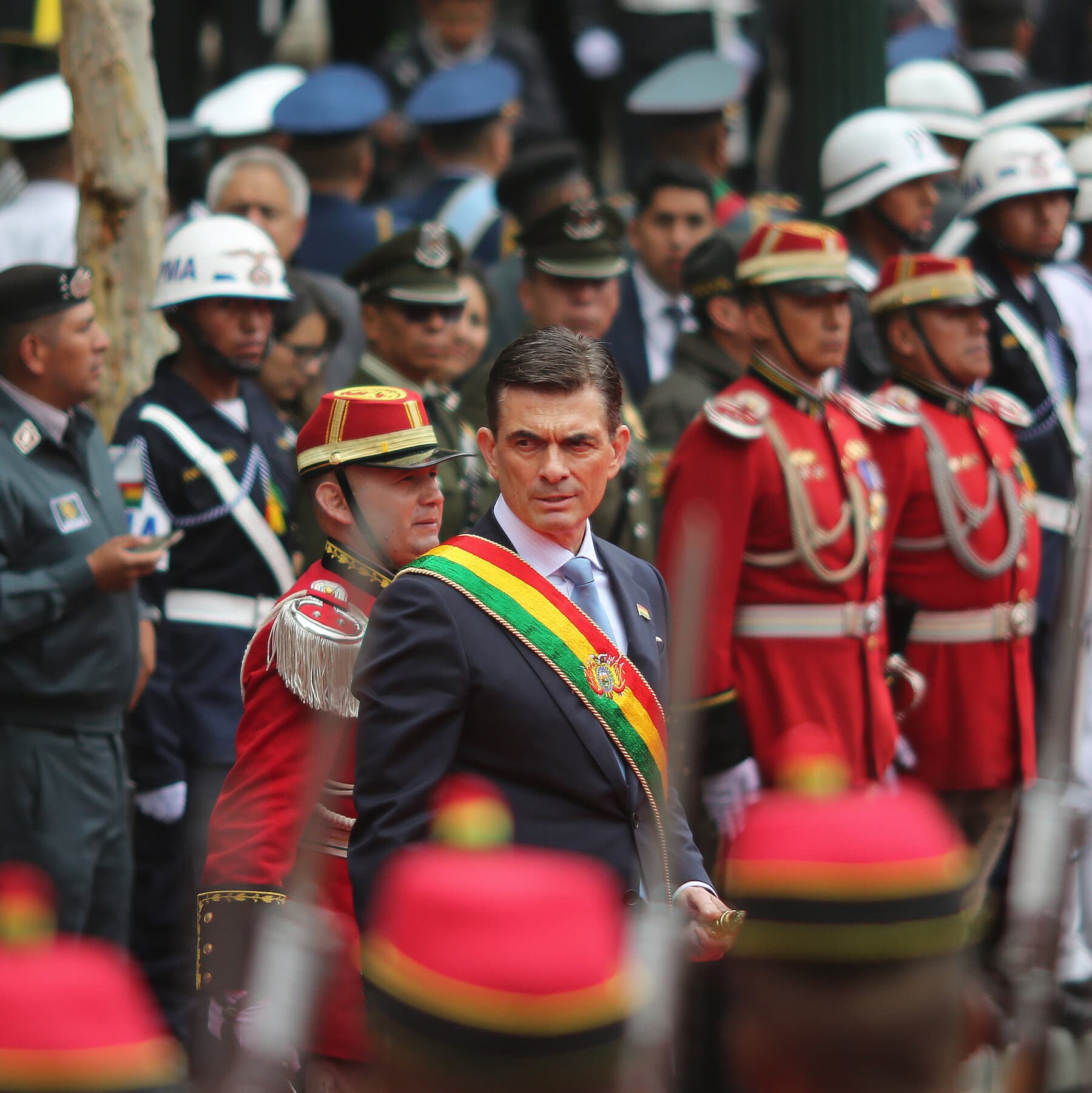 A group of politicians in expensive suits playing musical chairs in a smoky room, the chairs are painted with different flags, lighting is dim and gritty.