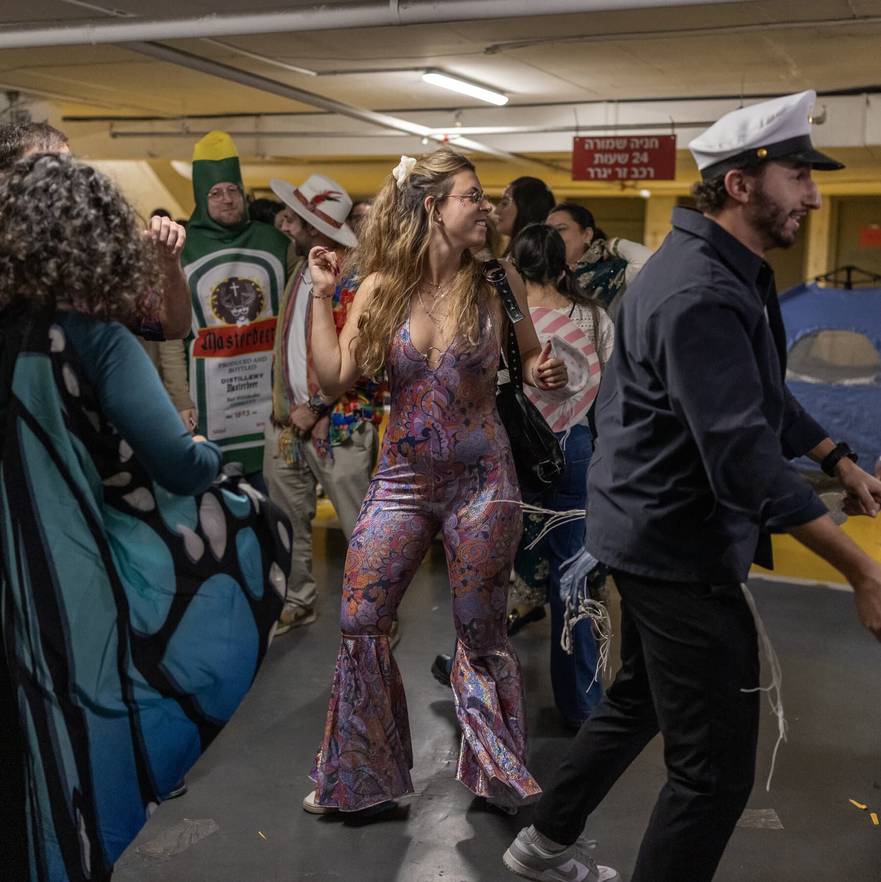 A gritty, cinematic night scene in a narrow Jerusalem stone street. In the foreground, Ultra-Orthodox men with blurred motion are dancing in a circle, wearing colorful Purim costumes like crowns and bright coats. In the dark sky above, faint, glowing trails of missile interceptions are visible, contrasting with the festive street lights below. High contrast, photo-journalistic style.